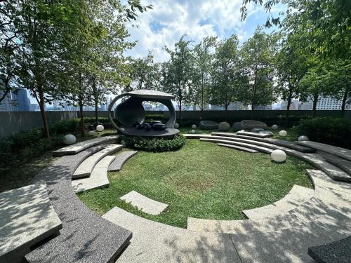a garden with a sculpture on the grass at Scartlez suites KLCC by Dream in Gua Sai