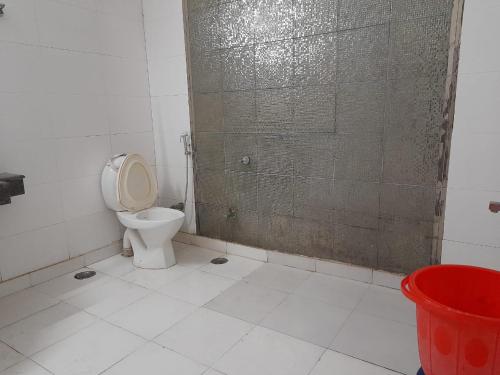 a bathroom with a toilet and a glass shower door at Hotel Mandakini in New Delhi