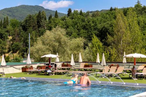 a man and a woman in a swimming pool at Palagina Il Borgo Agricolo in Figline Valdarno