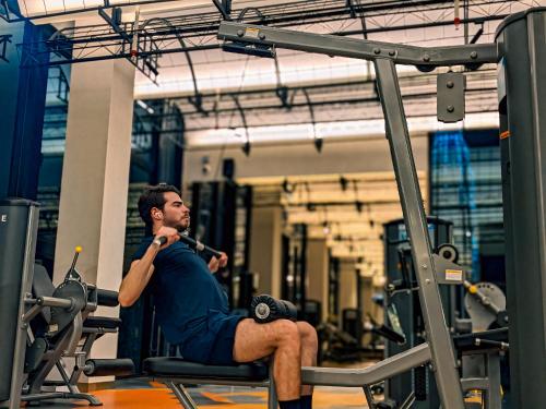 a man is sitting on a gym machine at Scartlez suites KLCC by Dream in Gua Sai