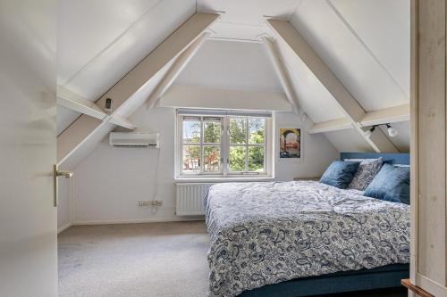 a bedroom with a bed and a window at Vakantiewoning Woudzicht - Stijlvol genieten in Nijkerk