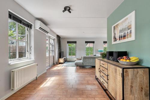 a living room with a couch and a television at Vakantiewoning Woudzicht - Stijlvol genieten in Nijkerk