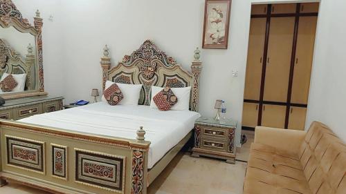 a bedroom with a large bed and a mirror at Hotel Business Boutique in Multan