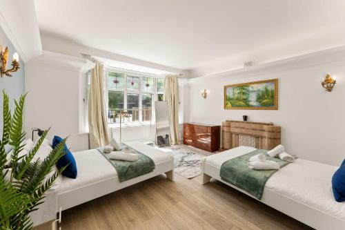 ein Schlafzimmer mit zwei Betten und einem Fenster in der Unterkunft Stylish 5 Bed Home in Forest Hill by Amber Stays, Perfect for Business & Contractors Sleeps 16 in Forest Hill