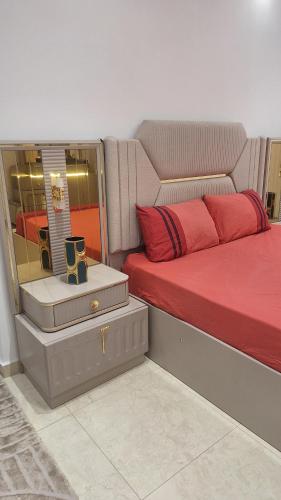 a bedroom with a red bed and a mirror at Luxe Suite au sein d'une villa in Rabat