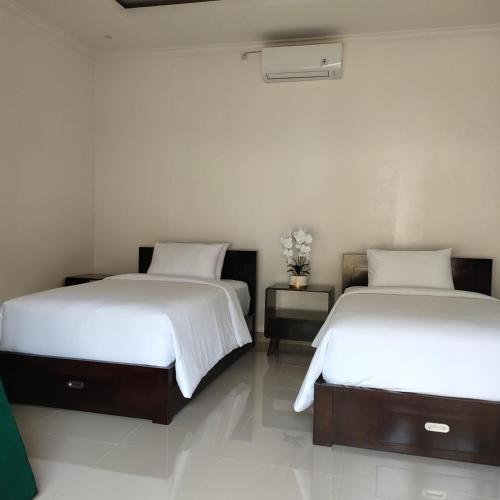 Dos camas una al lado de la otra en una habitación. en Jepun Bali Villa, en Temukus