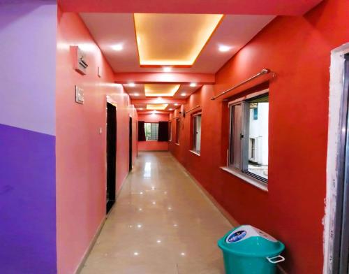 an empty hallway with red and purple walls and a trash can at Dream Residency Near Chinar Park in kolkata