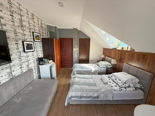 a bedroom with two beds and a tv in it at Willa Rudnik in Grudziądz