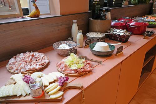 a buffet of food on a counter with plates of food at Mercure Bologna Centro in Bologna