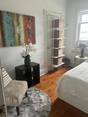 a bedroom with a bed and a chair and a table at Dreamers Writing Farm, 3 Wooded Acres, Hepworth in Sauble Beach