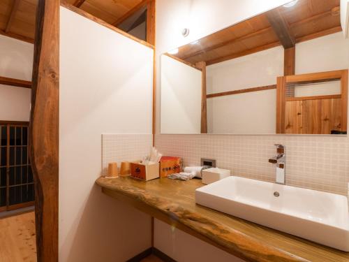a bathroom with a sink and a mirror at NIPPONIA Sado 佐渡相川 金山町 in Sado