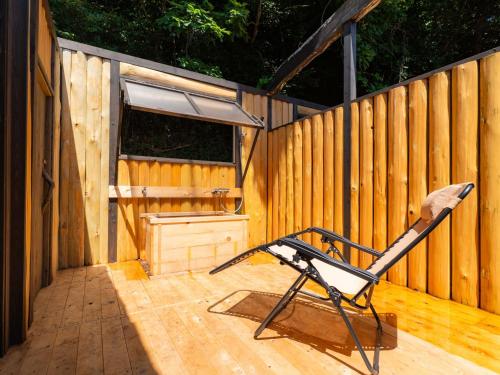 a chair sitting on a deck with a wooden fence at NIPPONIA Sado 佐渡相川 金山町 in Sado