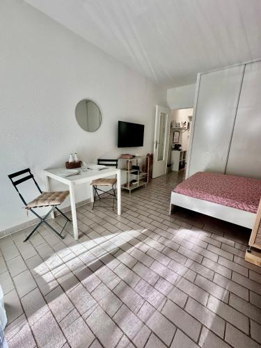 - un salon avec un lit, une table et un bureau dans l'établissement Studio sur le port de Hyères - à 2min des plages, Clim & Balcon, à Hyères