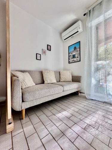 un salon avec un canapé et une fenêtre dans l'établissement Studio sur le port de Hyères - à 2min des plages, Clim & Balcon, à Hyères