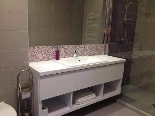 ein Badezimmer mit einem weißen Waschbecken und einer Dusche in der Unterkunft Rubin Apartman in Sárvár