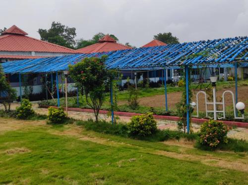 a row of buildings with blue roofs at Vrundavan home stay and Village resort in Kevadia