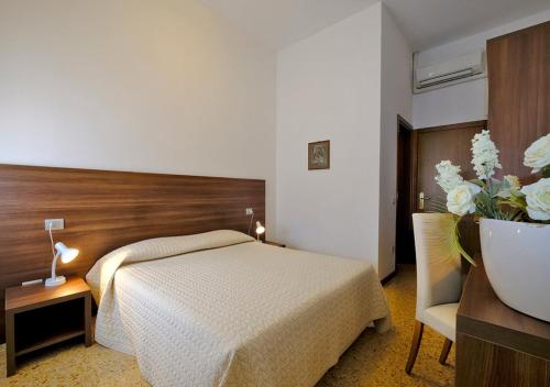 a bedroom with a bed and a table and a chair at Locanda Al Santuario in Peschiera del Garda