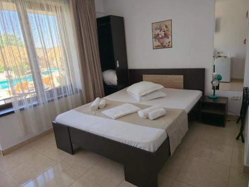 a bedroom with a bed with two towels on it at Complex Casa Ani in Eforie Nord
