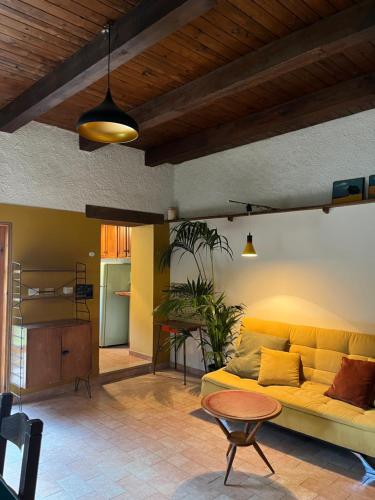 a living room with a yellow couch and a table at Vegan bed and breakfast Colle della luna in Borgo Pace