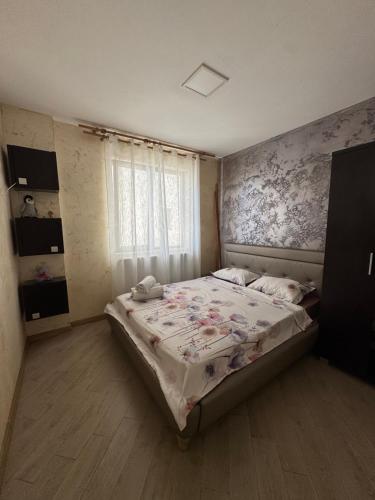 een slaapkamer met een groot bed met bloemenbehang bij Apartments 1 Mamaia Nord in Mamaia Nord – Năvodari