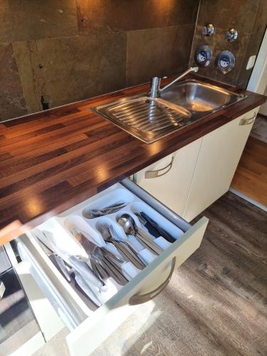 a kitchen with a sink and a drawer with utensils at Leo11 in Traunstein