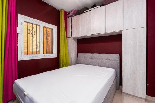 Bett in einem Zimmer mit farbenfrohen Vorhängen in der Unterkunft Campomanes Luxury Terrace Apartment in Alicante