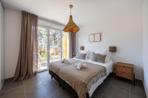 ein Schlafzimmer mit einem Bett und einem großen Fenster in der Unterkunft La Corniche Bleue in Sausset-les-Pins