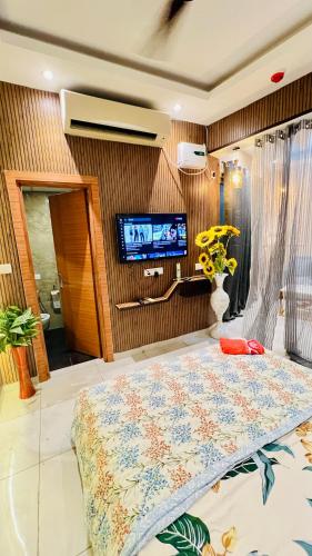 Un dormitorio con una cama y un televisor en la pared. en Atha the luxury studio 5, en Noida