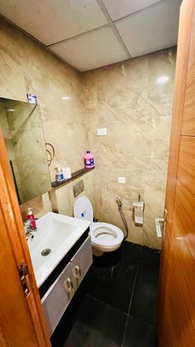 Un baño con un inodoro blanco y un lavabo. en Atha the luxury studio 5, en Noida