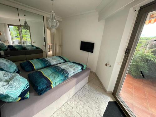a bedroom with two beds and a large window at Ferienwohnung Brissago in Brissago