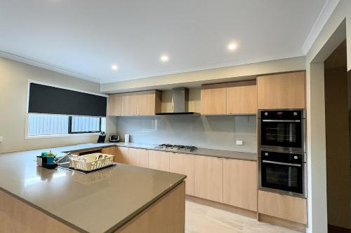 a kitchen with a large island in a kitchen at Casa Del Aria - Contemporary, Luxe Linens in Truganina