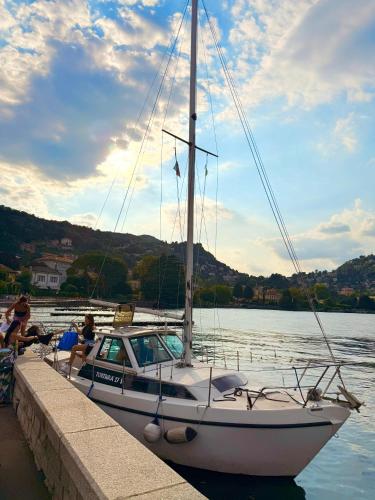 a sailboat is docked at a dock in the water at Como Lake View Enjoy&Relax in Brienno