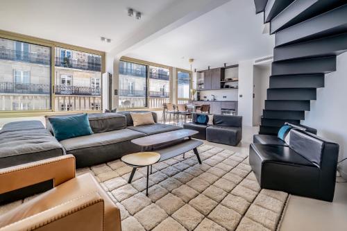 un salon avec un canapé et une table dans l'établissement Les Terrasses de l Arc, à Paris