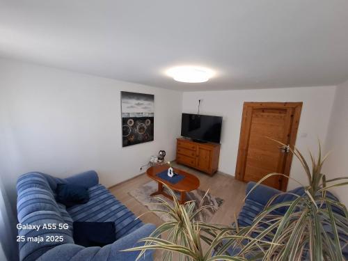 a living room with a blue couch and a table at Osada Chybotek in Przesieka