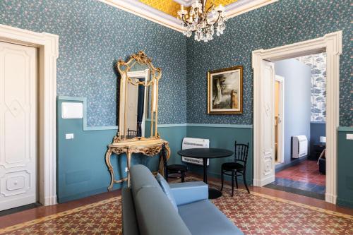 a living room with blue walls and a blue couch at Palazzo Giangreco Luxury Rooms in Avola