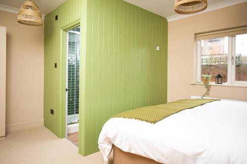 a bedroom with green walls and a bed at Settle Southampton - Stylish Self Check-In Rooms & Self Catering Suites in Southampton