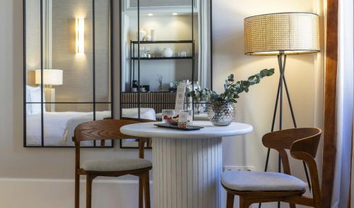 a room with a table with two chairs and a lamp at Hospes Palacio de los Patos, a Member of Design Hotels in Granada