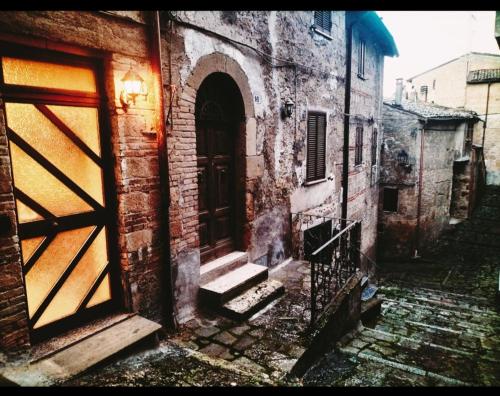 an old brick building with a door and stairs at La Casina di Tiro in Grotte di Castro