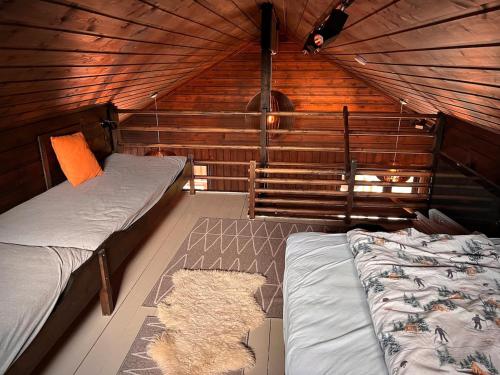 a room with two beds in a wooden cabin at Hytte på Norefjell in Surteberg