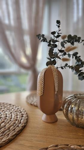 a vase with a plant in it on a table at White Hill's Nest in Zvejniekciems