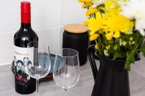 a bottle of wine and two wine glasses on a table at Settle Southampton - Stylish Self Check-In Rooms & Self Catering Suites in Southampton