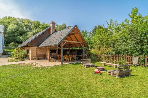 a barn with a picnic table and benches in the grass at Buškovský mlýn 1580 in Dolní Bousov