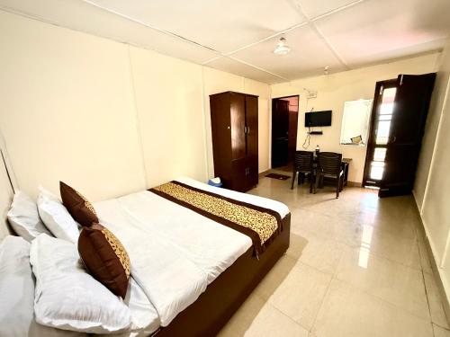 a bedroom with a bed and a living room at Hotel Kalka And Restaurant Patnitop in Kūd