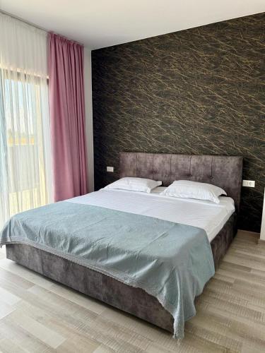 a bedroom with a large bed with a red wall at Apartament Lucas in Agigea