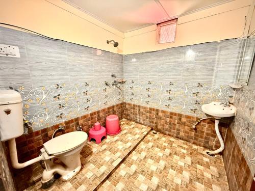 a bathroom with a toilet and a sink at Hotel Kalka And Restaurant Patnitop in Kūd