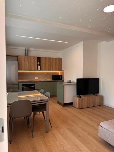 a living room with a table and a tv in it at Leonardo in Belluno
