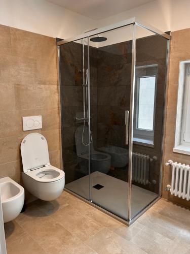 a bathroom with a toilet and a glass shower at Leonardo in Belluno
