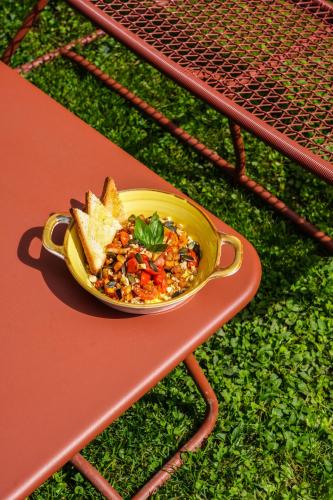 a yellow bowl of food on a table with bread at Mercure Bologna Centro in Bologna