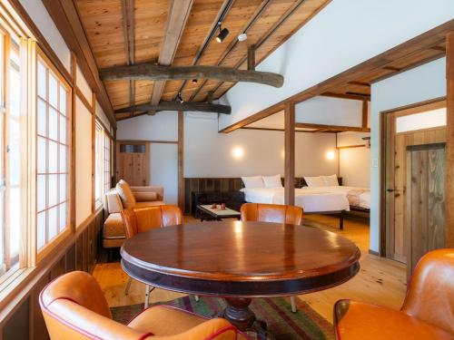 a dining room with a table and a bedroom at NIPPONIA Sado 佐渡相川 金山町 in Sado