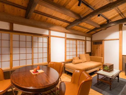 a living room with a table and a couch at NIPPONIA Sado 佐渡相川 金山町 in Sado